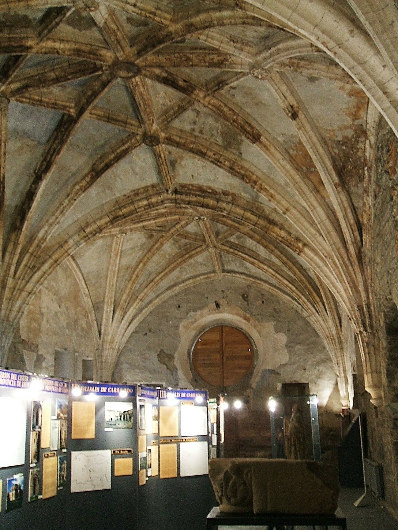 Gewölbter Klostergang mit Ausstellungsstücken